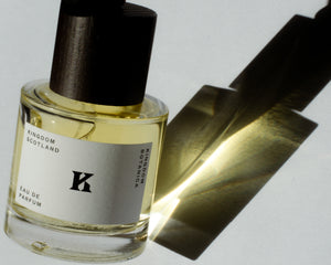 Bottle of Kingdom Botanica perfume with light and shadow reflection